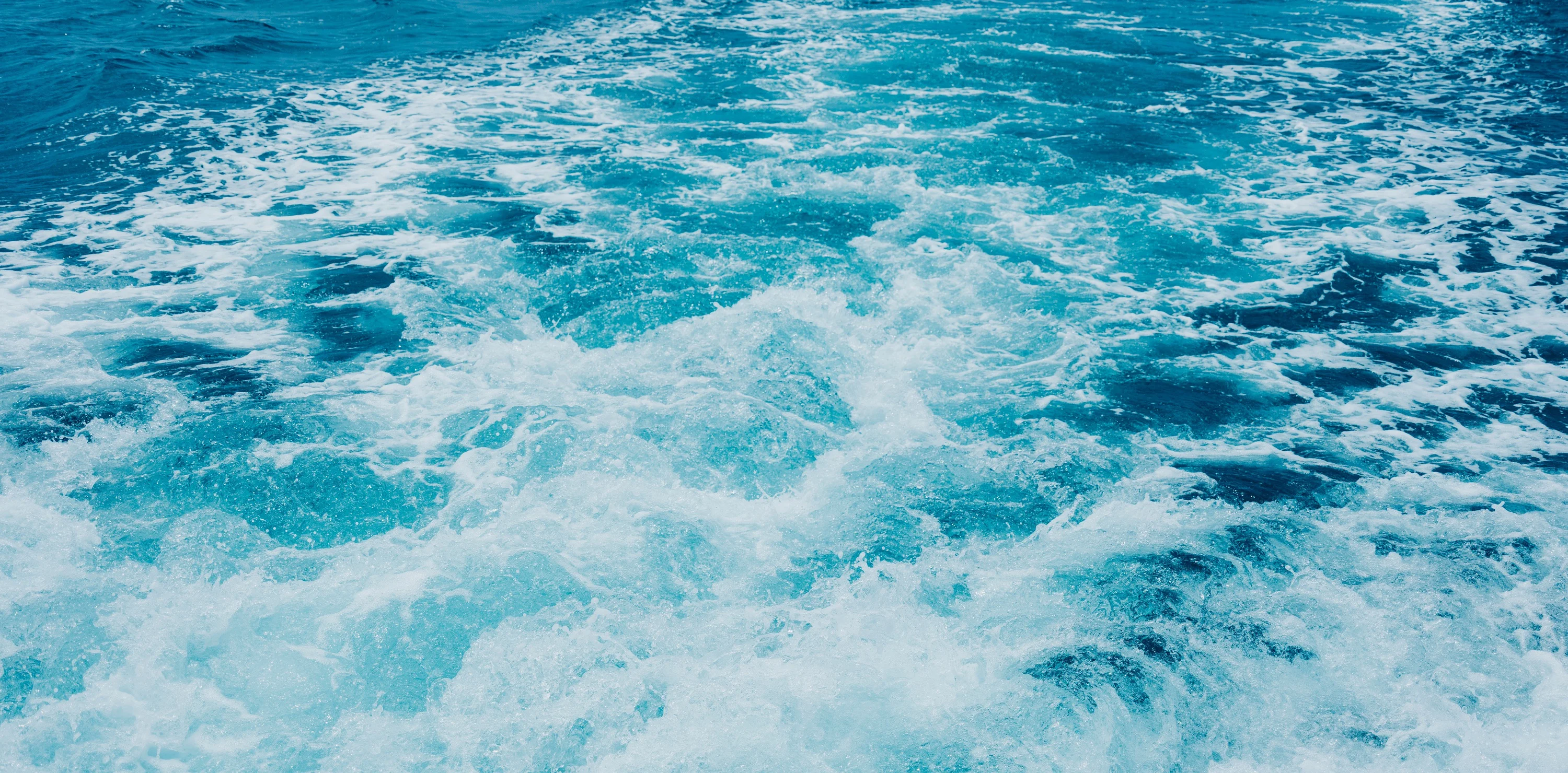 A ship's wake stretching across Okinawa's blue sea